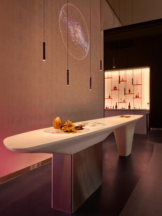 Tresen der Biophilic Bar im Fine Dining Restaurant The Cloud by Käfer mit Coro sospeso Pendelleuchten von Occhio und Projektion auf Perlino-Marmor